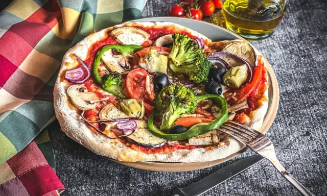 Eine bunte Pizza Veggie mit viel Gemüse wie Brokkoli, Paprika, Auberginen und Oliven.
