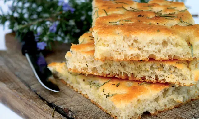 Stapel von knuspriger Focaccia mit Rosmarin, perfekt zum Belegen. Der Teig ist luftig und goldbraun gebacken.