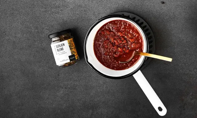 Ein Topf mit köstlichem Sugo di Pomodoro, daneben ein Glas "Sizilien Blend" Gewürzmischung. Perfekt für Pasta!