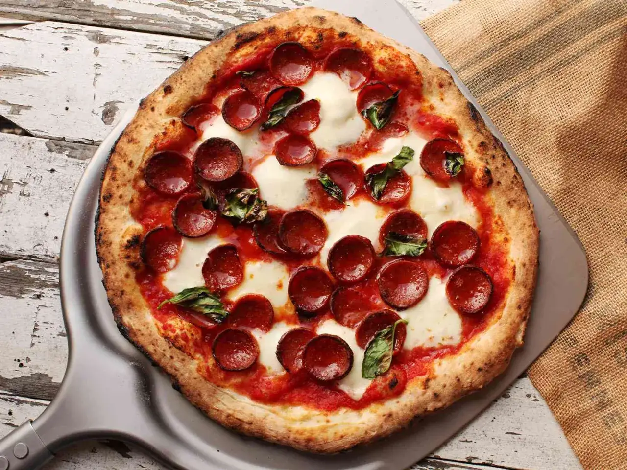 Eine köstliche neapolitanische Pizza, die Lust macht, sie selber zu machen. Mit Salami, Mozzarella und Basilikum.