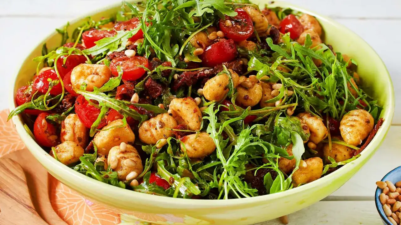 Herzhafter Gnocchi Salat mit Rucola, Kirschtomaten und Pinienkernen, ein köstliches Gericht für jede Gelegenheit.