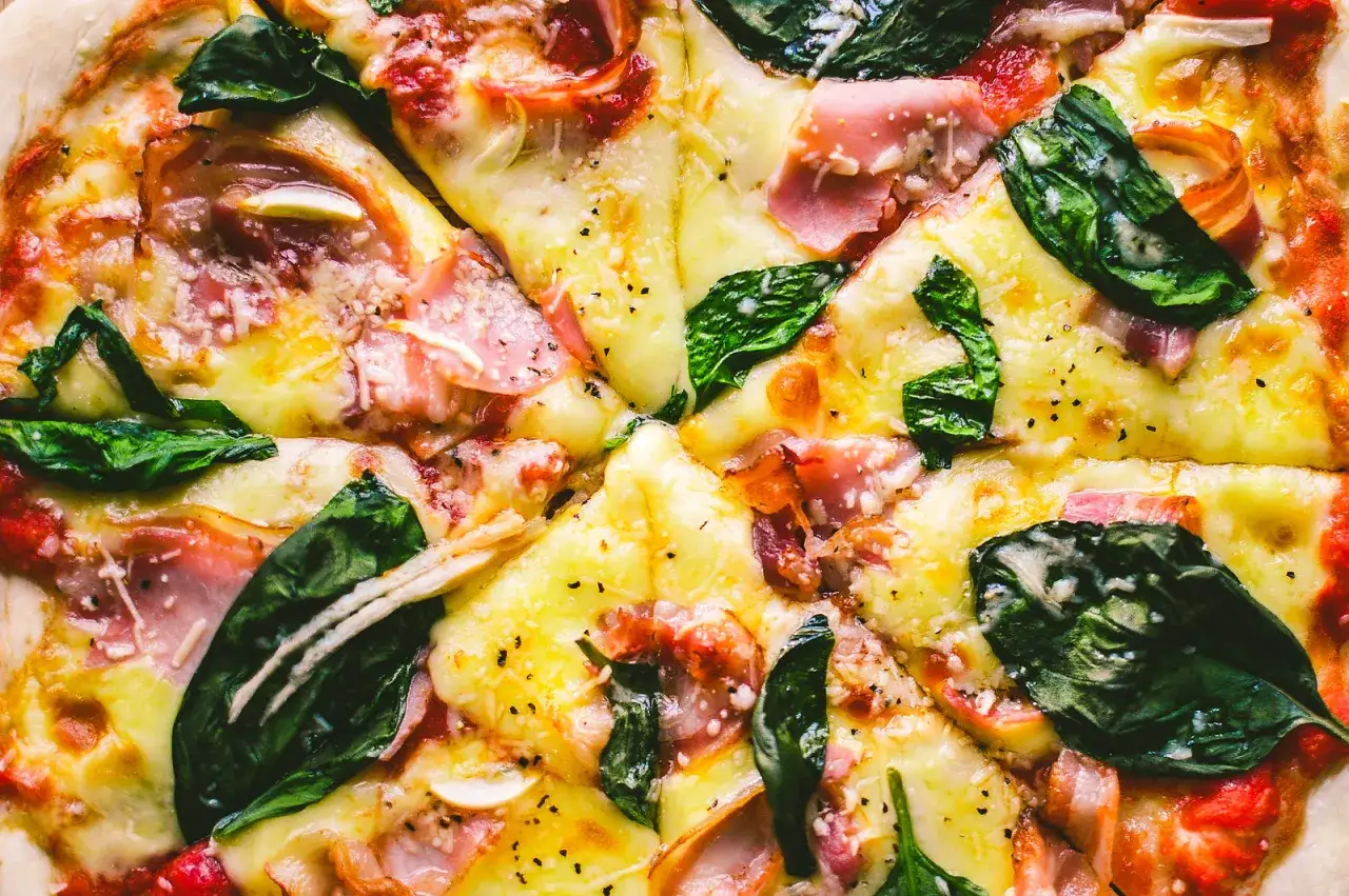 Eine k&ouml;stliche Pancetta Pizza mit geschmolzenem K&auml;se, frischem Spinat und knusprigem Speck.