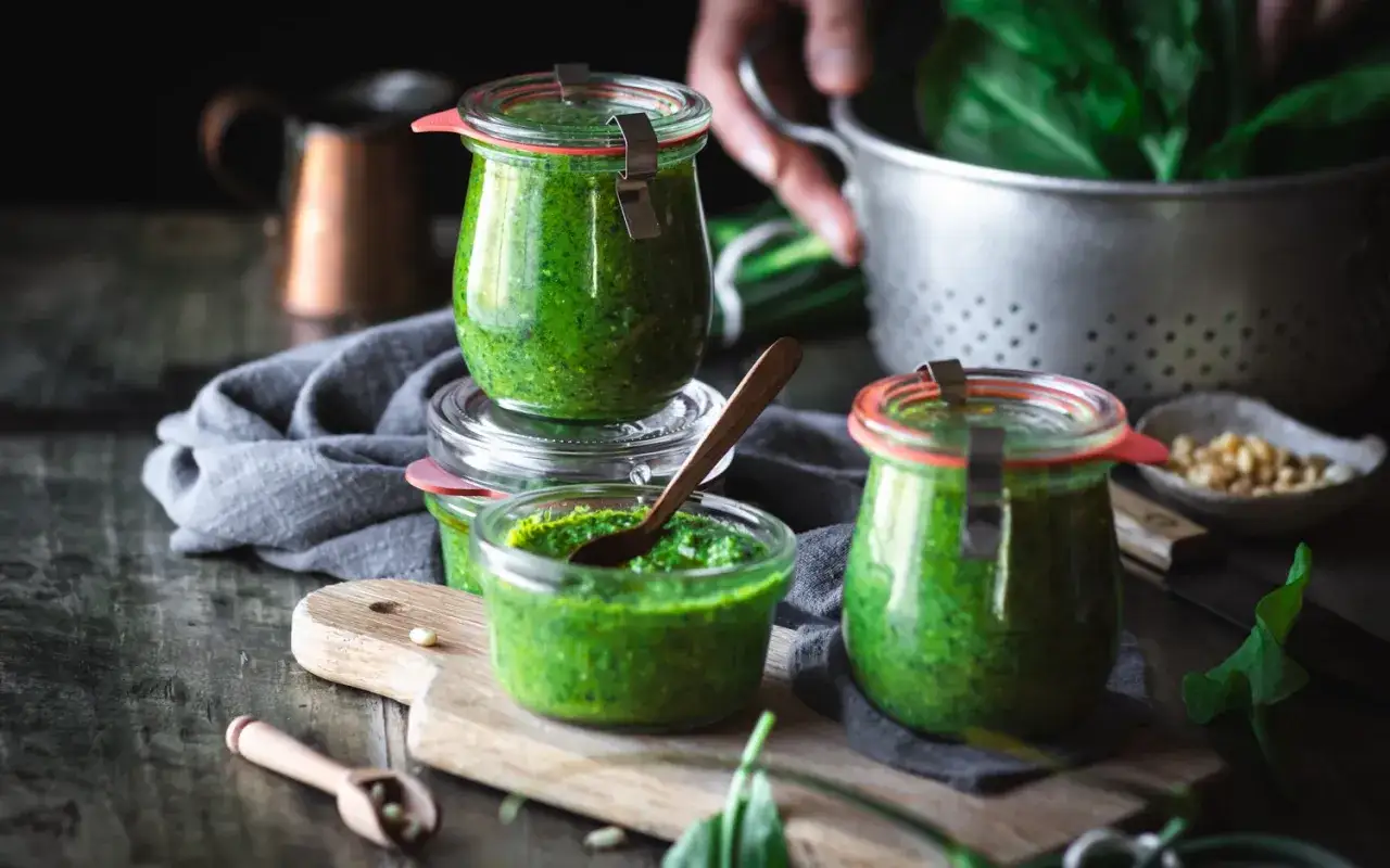 Frisches Sauerampfer-Pesto in Gläsern, bereit zum Genießen. Ein Löffel voller grüner Köstlichkeit.