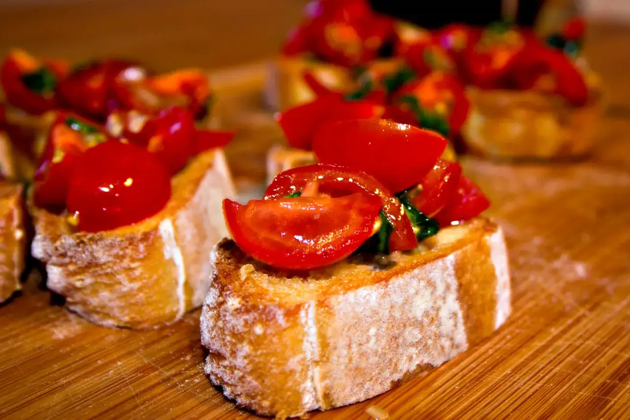 Knusprige Scheiben Brot mit frischen Tomaten belegt &ndash; Bruschetta, warm oder kalt ein Genuss.