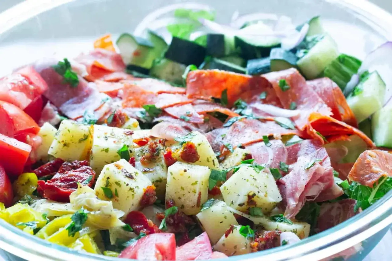 Bunter Kartoffelsalat mit Tomaten, Gurken, Salami und Kräutern. Perfekt für leichte Mozzarella Rezepte.