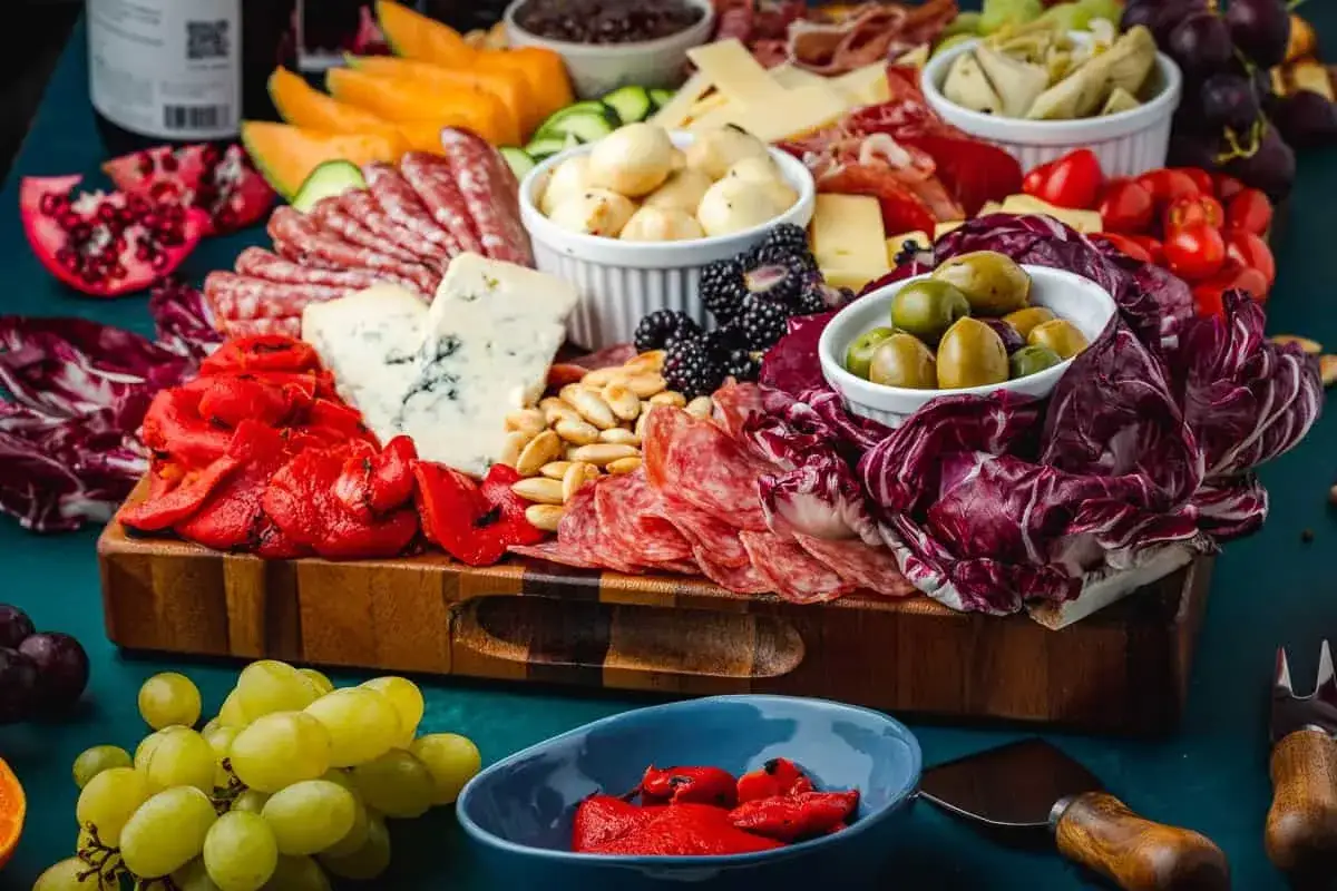 &Uuml;ppige Platte mit verschiedenen italienischen Salumisorten, K&auml;se, Oliven, Beeren und ger&ouml;steten Paprika.