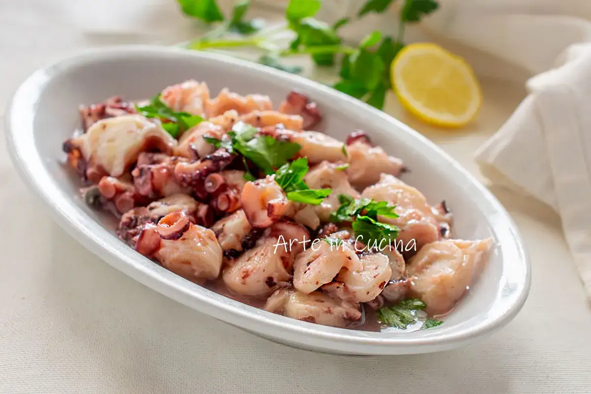 Insalata di polpo, ein k&ouml;stlicher Meeresfr&uuml;chtesalat mit zarten Oktopus-St&uuml;cken, garniert mit frischer Petersilie und einer Zitronenspalte.