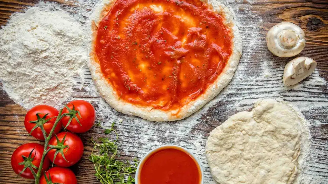 Pizza-Zutaten: Teig, Tomaten, Pilze, Kr&auml;uter und Mehl als semola alternative.