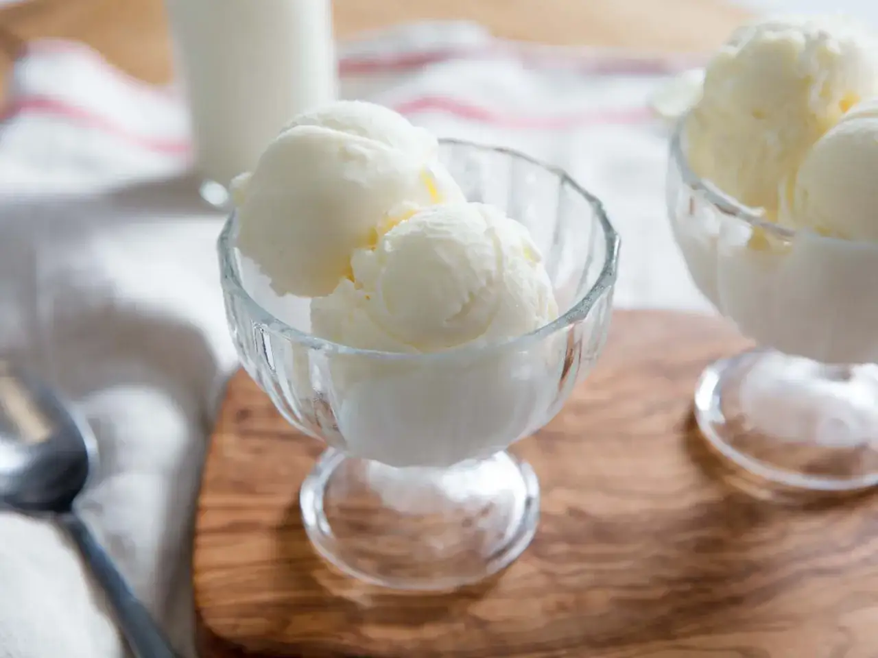 Zwei Schalen mit cremigem Fior di Latte Eis, bereit zum Genie&szlig;en. Ein L&ouml;ffel liegt daneben.