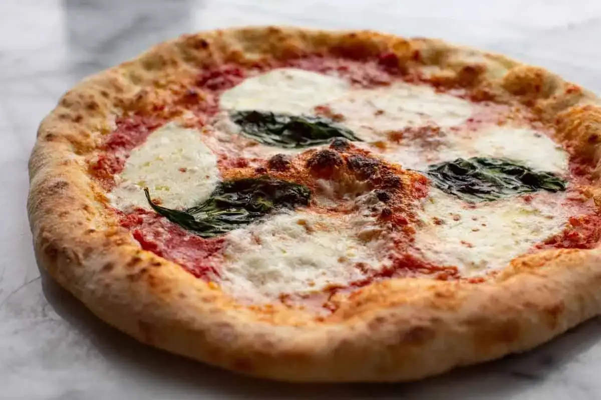 Pizza Margherita, mit luftigem pizzateig neapel thermomix zubereitet, belegt mit Tomatensauce, Mozzarella und Basilikum.