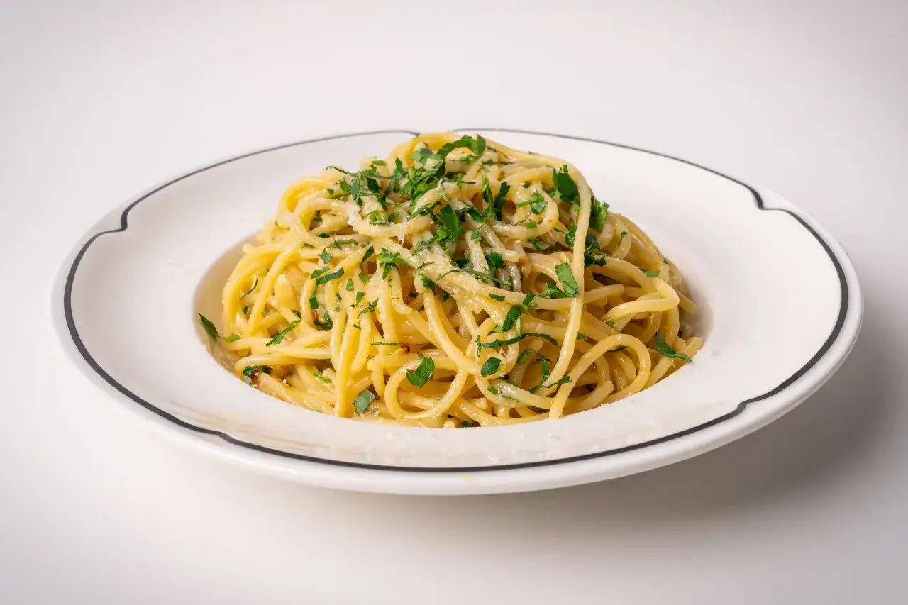 Ein Teller mit köstlichen Spaghetti Aglio e Olio, garniert mit frischer Petersilie und Parmesan.