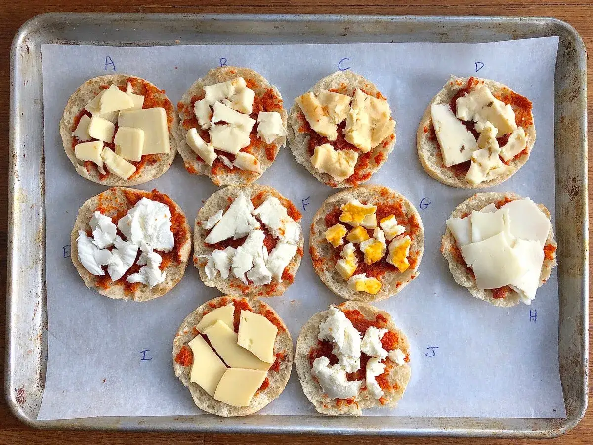 Zehn kleine Brotscheiben mit roter Paste und verschiedenen K&auml;sesorten belegt, als fior di latte alternative.