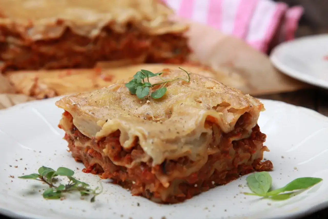 Herzhafte Linsen Lasagne, geschichtet mit Tomatensoße und Nudelplatten, garniert mit frischen Kräutern. Ein Genuss für jeden Tag.
