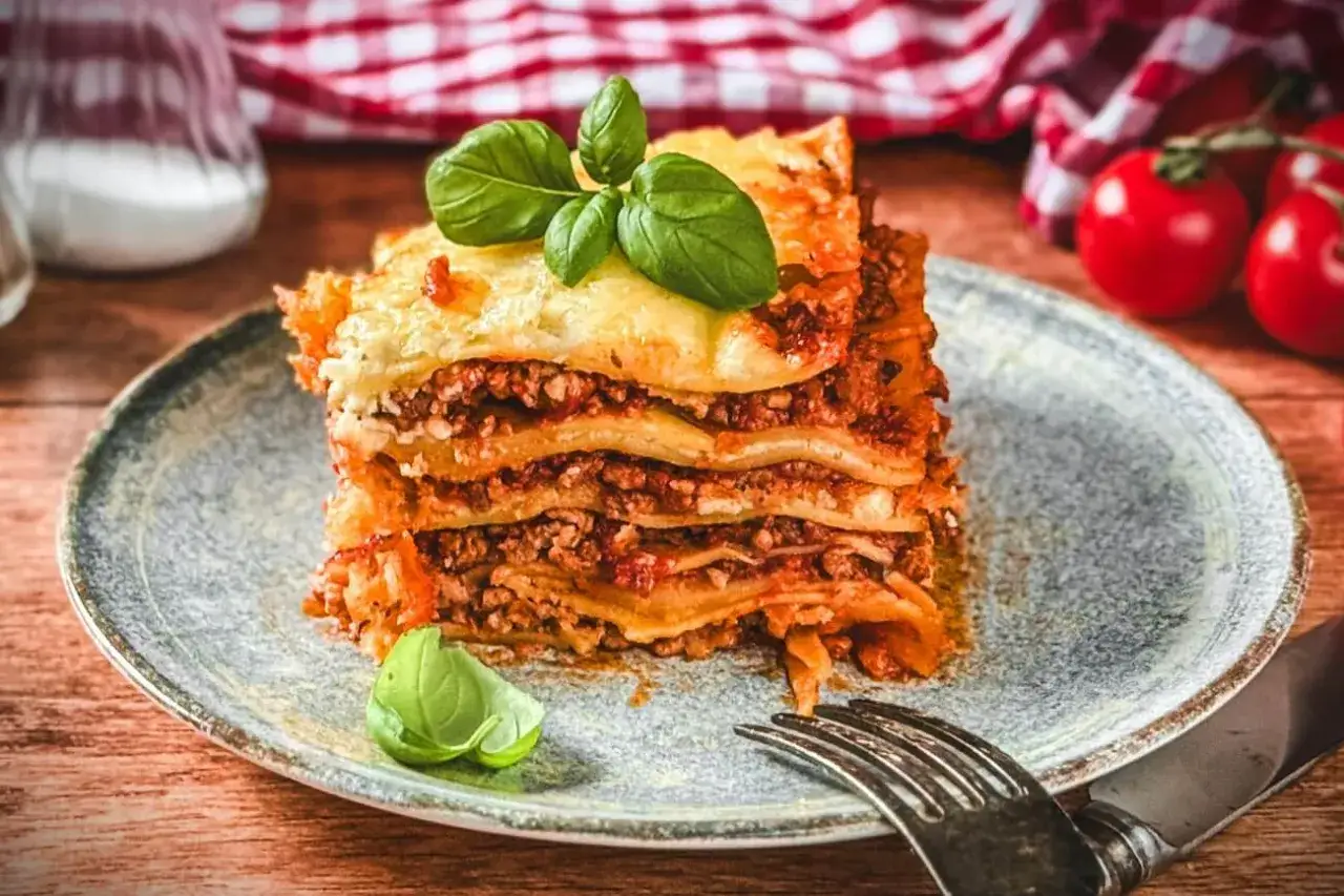 Ein köstliches Stück Lasagne mit Hackfleisch und Käse, garniert mit Basilikum. Perfekt für ein gemütliches Abendessen nach diesem Lasagne Rezept.
