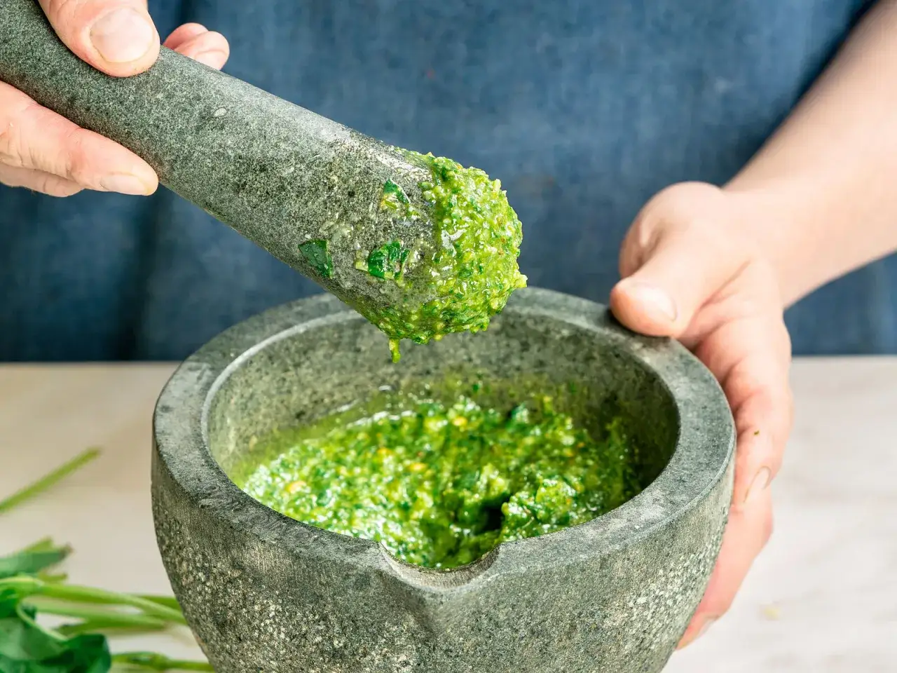 Frisches Pesto wird im M&ouml;rser zubereitet. Ein k&ouml;stliches Rezept f&uuml;r selbstgemachtes Pesto.